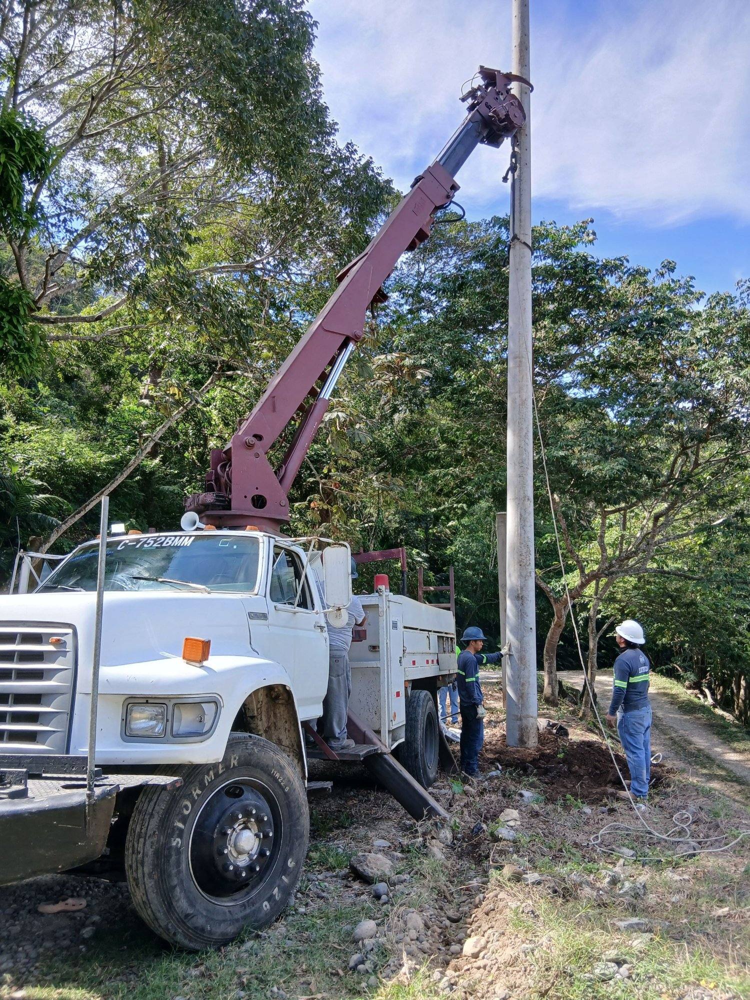 Camión grúa de EISA instalando un poste de media tensión