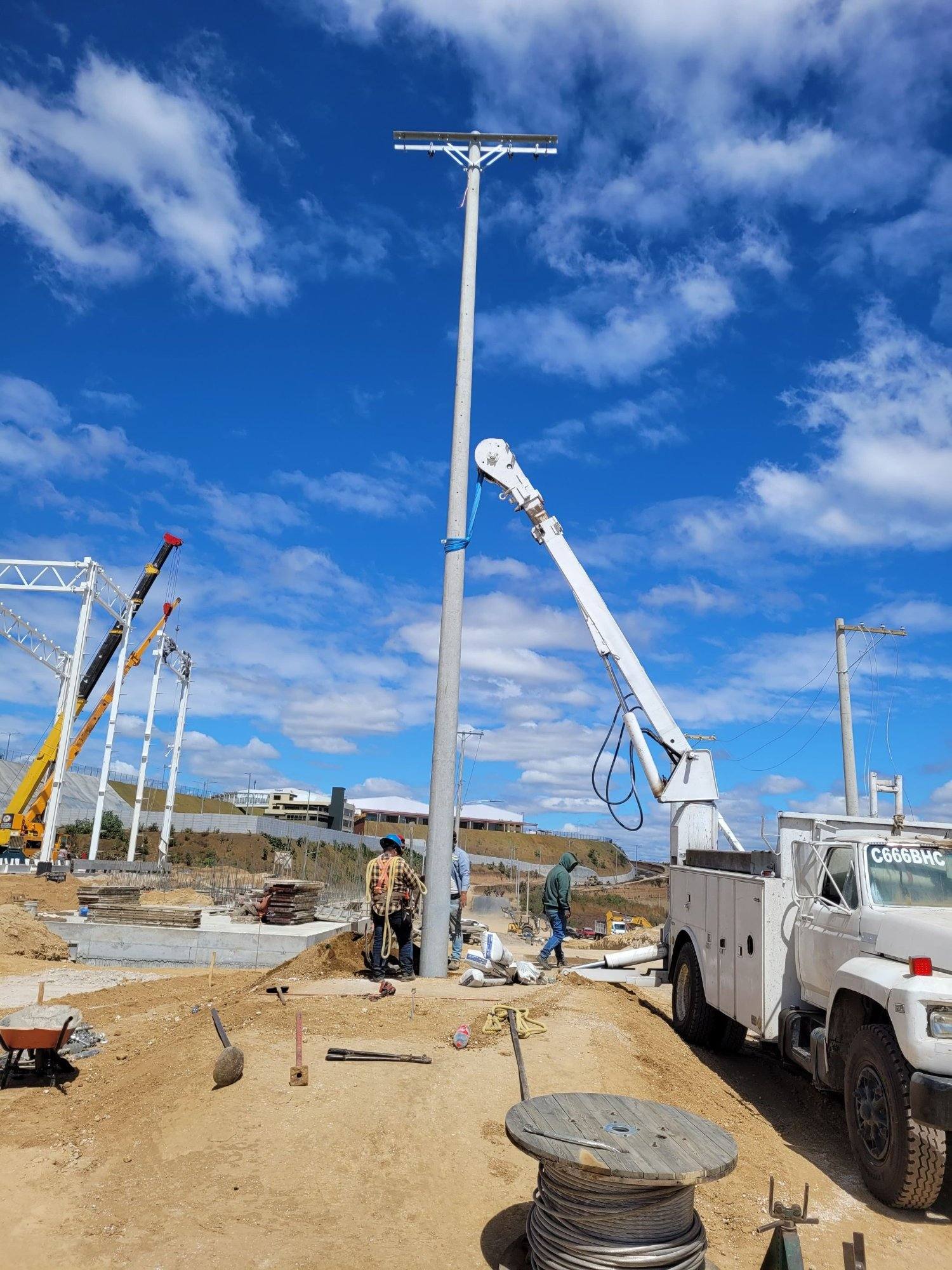 Cuadrilla de EISA colocando un poste con grúa en un proyecto industrial